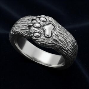Close-up illustration of a ring with an intricately engraved cat paw detail.