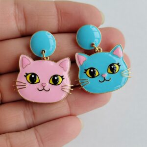 Cute pastel cat earrings in pink and blue, featuring cartoon-style cat faces with big eyes and glossy enamel finish… 